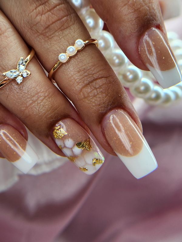 French tip nails with gold leaf and pearl rings